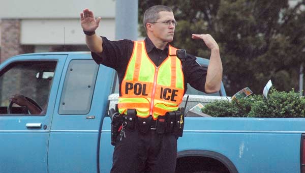 Chris Thomas, a patrolman with the Franklin City Police, directs traffic at the intersection of Armory and College drives on Friday. -- Charlie Passut | Tidewater News