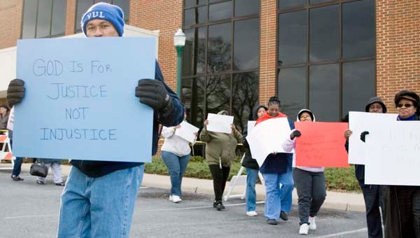 Raymond Williams, left, and other members of the Concerned Citizens Against High Utility Bills group, march at City Hall during a protest against rising utility costs, prior to Monday’s City Council meeting. -- ANDREW FAISON/TIDEWATER NEWS