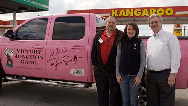 Franklin Kangaroo Store Manager Randy Bullock, left, poses with Nicole Connor, Victory Junction spokeswoman, and Kangaroo District Manager David Stover in front of the Victory Junction Pink Truck, donated by country music star Taylor Swift. -- ANDREW FAISON/TIDEWATER NEWS