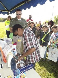 Brandon Rodgers of the Western Tidewater Community Services Board, left, watches as Joseph Harris of Nottoway Elementary tries to put toothpaste back into the tube at the inaugural Safety Jamboree held Friday. Rodgers compared the task of trying to undo damage caused by bullying. -- STEPHEN H. COWLES/TIDEWATER NEWS