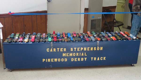 Cars from the Siouan Rivers District Pinewood Derby sit on top of the box that transports the 42-foot aluminum track they will soon race on. -- SUBMITTED/ Robin Pope