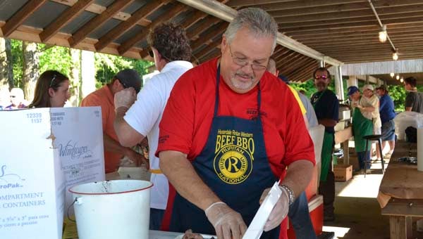 Hunterdale Ruritan Beef Barbecue co-chair Paul Phillips serves up a plate of sliced barbecued top sirloin, baked beans, cole slaw and rolls Wednesday at the club’s 50th annual fundraiser. -- Mitzi Lusk | Tidewater News