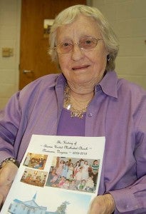 Betty Darden holds a picture of the book on the last 10 years of Barnes United Methodist Church. -- MERLE MONAHAN/TIDEWATER NEWS
