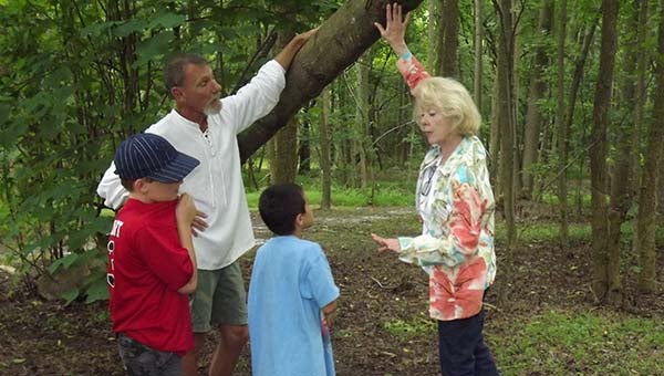 Christopher Cornwell, front, Randy Moore, back, and Brock Smith listen as Ruina Senkovich, a Master Gardener and tree steward, talks about trees: their kinds, purpose and even hazards they can present. -- Stephen H. Cowles | Tidewater News