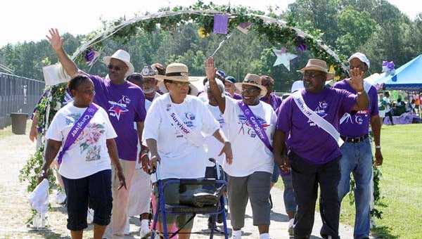 Charlotte Blacknall (with walker) passes through the Relay Arch Saturday during the annual Franklin/Southampton Relay for Life. Blacknall a nine-year cancer survivor and has participated in the event for the past six years. Pictured are, from left, Barbara Harris, caretaker for Mrs. Blacknall, Charlotte Blacknall, Ida and Rev. Richard Powell, Donald Murell, and back row waving, Delma Murell. -- FRANK A. DAVIS/TIDEWATER NEWS