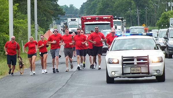Isle of Wight County Sheriff’s Deputy J.P. Hopko, left, runs in the annual Virginia Law Enforcement Torch Run on Route 17 on Thursday. With him from the office are Tiffany Bryant and Christina Kearney, both in administration; Smithfield Police Officer Daniel Fordham; IOW Deputy Steven Borst; IOW Sheriff Mark Marshall, carrying the Special Olympics Torch; IOW Maj. James Clarke; and IOW Deputy Donald Edwards. -- Submitted | IOW Sheriff’s Department