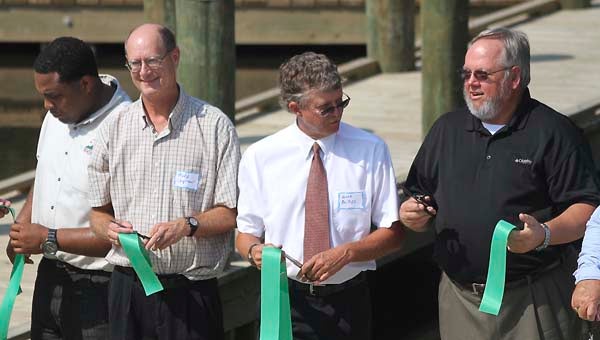 Officials hold their pieces of ribbon after cutting it for dedicating the Hercules Boat Launch. -- CAIN MADDEN | Tidewater News