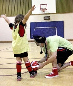 Soccer camp coach Will Harris works on a trick move with 6-year-old Evelyn Clark. -- CAIN MADDEN|TIDEWATER NEWS