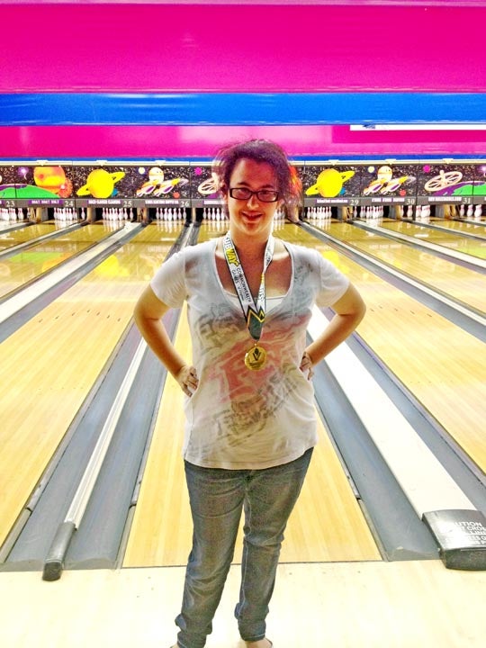 Megan Coburn, 17, stands before lanes where she played in Christiansburg last weekend in a bowling tournament. Coburn's wearing the gold medal she won for her category. SUBMITTED PHOTO