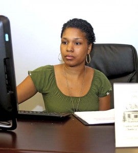 Tiffany Warren of Warren Investments Group checks records at her office at the Business Incubator in downtown Franklin. -- Cain Madden | Tidewater News