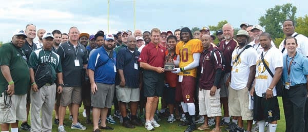Local coaches Lakenneth Kindred, Daniel Johnson, Darren Parker, Karl Robertson, Travis Lane and Willie Gillus attended the Redskins' Coaching Clinic. Some of the 250 coaches that participated are pictured along with Redskins QB Robert Griffin III and Redskins legend Joe Theismann. Theismann presented Griffin III with the Quarterback Award from the Quarterback Club of Washington. -- SUBMITTED
