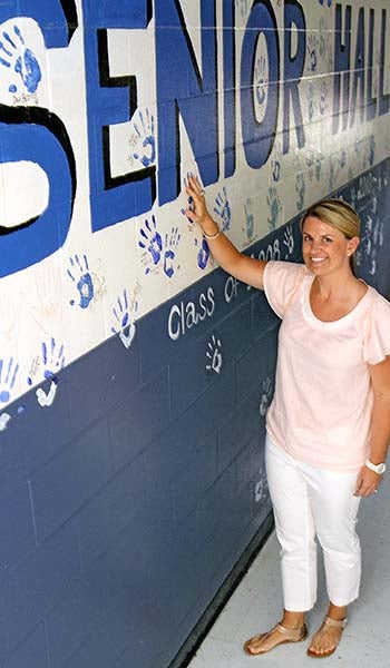 New Tidewater Academy Head of School Frances Joyner stands in Senior Hall by the handprints, where her handprint once adorned the wall. Joyner hopes to keep alive traditions such as this, foster new ones and bring back others. -- CAIN MADDEN | TIDEWATER NEWS