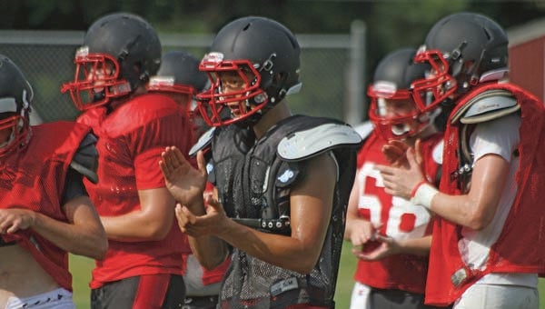 Isle of Wight Academy players clap on other players after running through conditioning excercises in a recent practice -- Cain Madden | Tidewater News