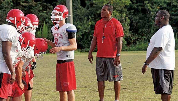 Southampton Head Coach Willie Gillus Jr. shouts out tips to his team during practice, while QB Russell Ballance leads the offense in a drill. The Indians are set to play the Presidents today at 6 p.m. in Courtland. --CAIN MADDEN | TIDEWATER NEWS