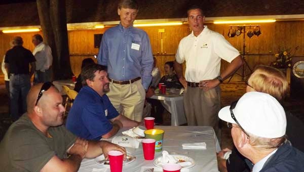 John Keppler, standing at right, talks with guests at the Enviva Pellets Southampton Pig Pickin’ held last Wednesday at the Fairgrounds. The event was held to thank employees and supporters. Keppler is chairman and chief executive officer of Enviva LP. At left is Warren Beale, chairman of the FSEDI board of directors. -- STEPHEN H. COWLES | TIDEWATER NEWS