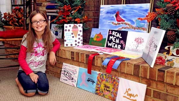 Madelyn Cosby, 10, poses with some of the artwork that will be featured in her silent auction on Oct. 5 from 2 to 4 p.m. at the Sedley Baptist Church. She is auctioning off her artwork and other items for a friend with cancer and the Susan G. Komen Foundation. -- Cain Madden | Tidewater News