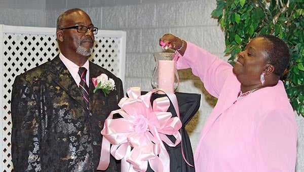 Audrey Lee lights the memorial candle with her husband Duke Lee. -- FRANK DAVIS | TIDEWATER NEWS