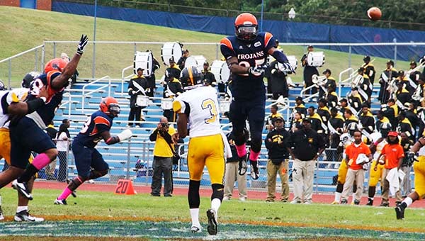 Andre Rawls goes high in the air attempting to block a pass by the Bulldogs quarterback. -- ALMETA DAVIS | TIDEWATER NEWS