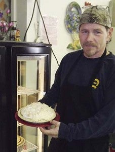 Randy Bryum, co-owner of The Hungry Rooster, holds up one of the many homemade desserts prepared at the Boykins restaurant. He and his wife, Denise bought the place in March. -- STEPHEN H. COWLES | TIDEWATER NEWS