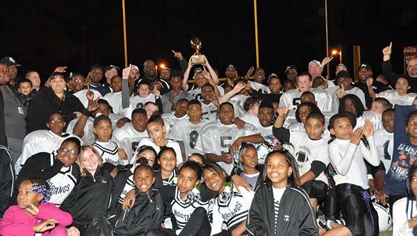 The Mustang football coaches, players and cheerleaders gather after the game to hold up the team championship trophy. -- JIM HART | TIDEWATER NEWS