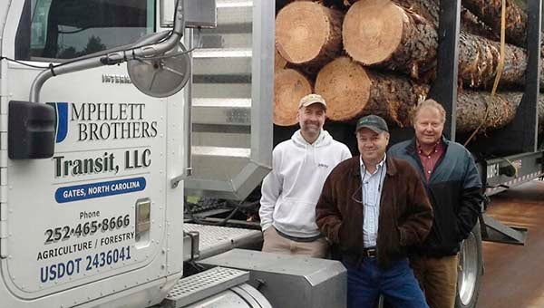 Franklin Lumber LLC bought its first load of logs on Nov. 5 from S&M Timber Products Inc. of Sunbury, N.C. Terry Godwin, left, who is the new mill’s procurement manager, is with Carl Buck and Perk Taylor, chief executive officer. Franklin Lumber anticipates opening next Monday. -- SUBMITTED