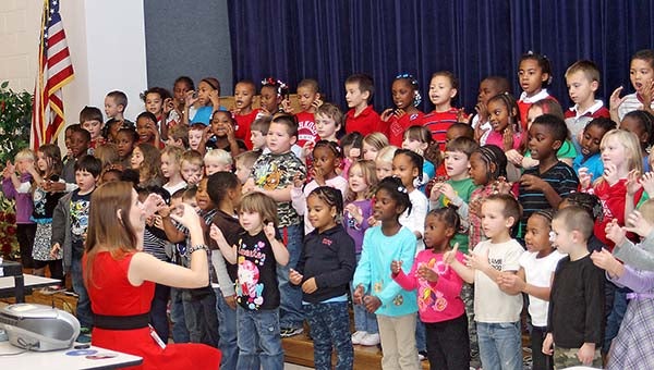 Pre-Kindergarten to fifth grade music teacher Lynn Varian works with the pre-K, Kindergarten and first grade students on their song and sign language tribute to veterans. -- CAIN MADDEN | TIDEWATER NEWS