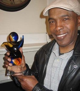 Terry Scott of The Scotts holds up the 2013 AMG Retro Artist of the Year Award, which was presented earlier this month to the Southern gospel family of singers. -- STEPHEN H. COWLES | TIDEWATER NEWS