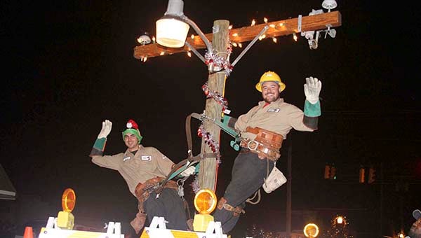 Franklin Power and Light employees Chris Stallard, left, and Brian Shifflett, wave to the crowd. The float took second place for best use of lights in Franklin’s 2012 parade. -- FILE