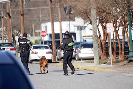 Police officers search downtown for the suspects, who fled on foot. Photo by Cain Madden