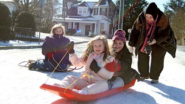 Elizabeth Russell, 10, and Kim Fresen, watch Katie, 8, and Sarah Fresen, 10, go down the hill. -- Cain Madden | Tidewater News