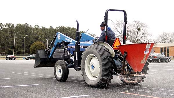 Clayton Smith of the Paul D. Camp Community College ground's crew works to put out salt in the parking lot. -- Cain Madden | Tidewater News