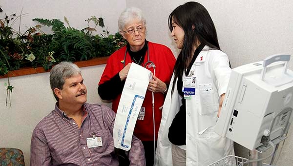 Cardiologist Chikako Ono talks with Wayne Jennings about his blood pressure, after Shirley Lee, R.N., finished his free screening. -- CAIN MADDEN | Tidewater News
