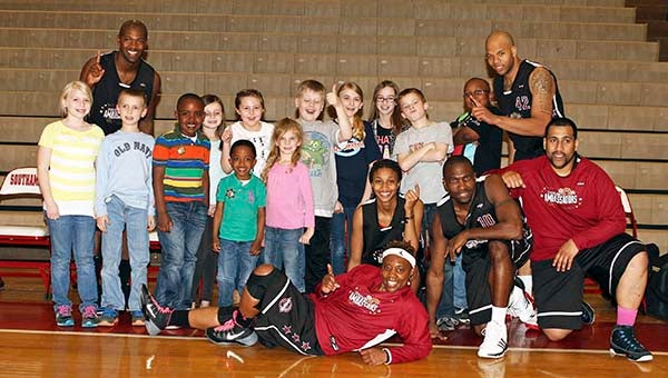 Harlem Ambassadors pose with youth on the bench. -- Frank Davis | Tidewater News