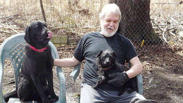 Harry Darby sits outside in the back yard with Brooks, left, Toto and Smokey. Healthy reasons are compelling Darby to close his K9 Rescue service, and he’s looking for good homes for them. Brooks, by the way, has been adopted. -- STEPHEN H. COWLES | TIDEWATER NEWS