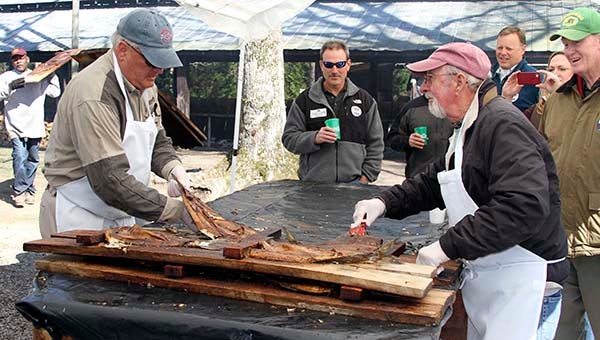 Wakefield Ruritans cut shad from wooden planks at the 66th Wakefield Ruritan Club Shad Planking on Wednesday afternoon. -- DON BRIDGERS | TIDEWATER NEWS