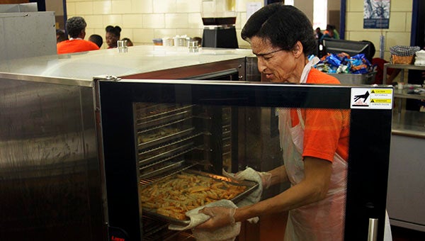 Cafeteria worker Salina Smith unloads a tray of fries from one of the new combi-ovens at S.P. Morton Elementary School. -- CAIN MADDEN | TIDEWATER NEWS