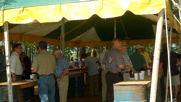A crowd gathered under a tent at the Windsor Ruritan Pig Pickin' -- Merle Monahan | Tidewater News