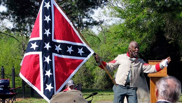 H.K. Edgerton, a self-described “black Confederate activist” waves the Confederate flag during a dramatic moment of his presentation on Saturday morning in Courtland. He was the guest speaker for the Memorial Day observance hosted by the Urquhart-Gillette Camp 1471 Sons of the Confederate Veterans. -- STEPHEN H. COWLES | TIDEWATER NEWS