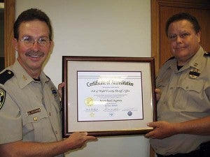 Isle of Wight County Sheriff Mark Marshall, left, and Capt. Joe Willard hold up the office’s Certificate of Accreditation. This is a first for the department, and Marshall intends to maintain the status. -- STEPHEN H. COWLES | TIDEWATER NEWS