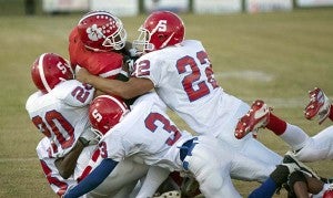 Lawrence takes part in a tackle during a game against Surry. -- MURRAY THOMPSON | TIDEWATER NEWS