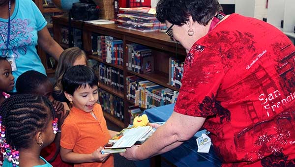 S.P. Morton Bright Starts child Ari Martin smiles big as Librarian Patricia Rideout hands him his four free books that were obtained by the school through grants. -- CAIN MADDEN | TIDEWATER NEWS