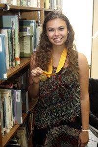 Rachel White holds up her valedictorian medal in the library. -- CAIN MADDEN | TIDEWATER NEWS
