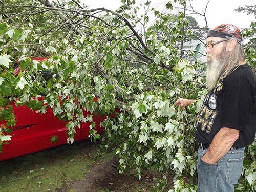John Smith of Main Street in Capron shows how a part of a tree had crushed the bed and top of his 1999 Dakota Sport. Photo by Stephen Cowles.