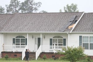 Viola Worrell of Buckhorn Quarter Road takes a picture of the damage done to her roof by the storm that came through Thursday afternoon. Photo by Cain Madden.