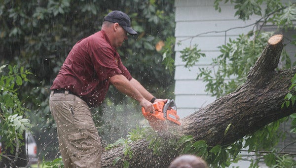 Sgt. Greg Griffith helps clear a tree from a Capron home. Photo by Cain Madden.