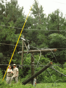 Workers for Community Electric Cooperative work to untangle fallen power lines on Country Club Road. Then they had to deal with the broken pole.