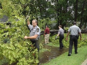 Southampton Deputy J.H. Fuller carries away a branch in front of Smith's home. With him are Deputies C. Sherrill and H.K. Rose. They, along with Sheriff J.B. Stutts and other deputies were busy on Thursday after an intense storm hit the western part of the county earlier that afternoon. Photo by Stephen Cowles.