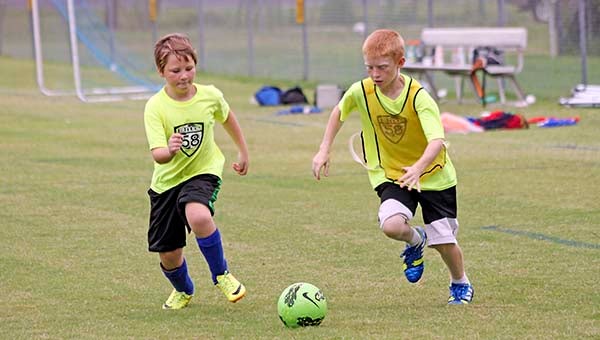 Nico Gamboni, 11, and D.J. Dillon, 10, chase after a ball during a scrimmage game at Elite 58 Soccer Camp. Dillon came in first place during the Elite 58 Shootout for ages 9-10. -- Cain Madden | Tidewater News