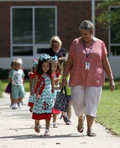 The Hutto triplets Caroline, Carson and Chaney, all 4-years-old, walk with Sharon Mallon. They are in the Pre-K class. -- CAIN MADDEN | TIDEWATER NEWS