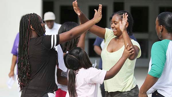 From left, Cierra White, 14, Racquel Turner, 13, Rajhane Turner, 8, Kayce Gray, 13, and Cortney Jones, 13, high five after touring the new Georgie D. Tyler Middle School. -- CAIN MADDEN | TIDEWATER NEWS